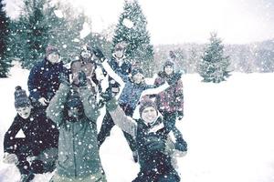 grupo de jovens jogando neve no ar foto