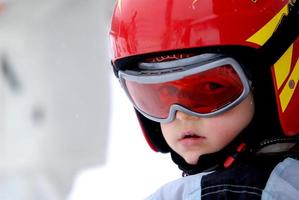 pequeno esquiador com capacete e óculos foto