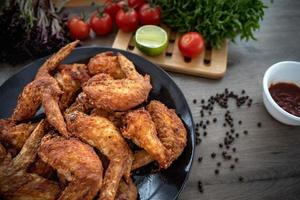 pratos de carne quente - asas de frango frito no prato com salada foto