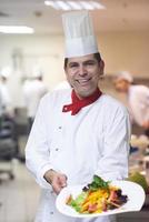 chef na cozinha do hotel preparando e decorando comida foto