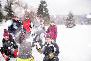 grupo de jovens jogando neve no ar foto