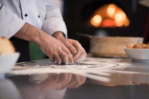 mãos de chef preparando massa para pizza foto