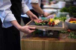 chef feminino segurando o prato de bife foto