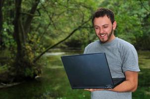 jovem empresário trabalhando no laptop ao ar livre foto