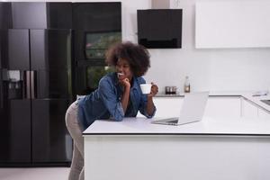 mulher negra sorridente na cozinha moderna foto