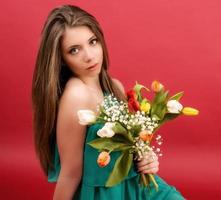 garota linda em um vestido de verão com tulipas