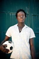 homem africano segurando uma bola de futebol