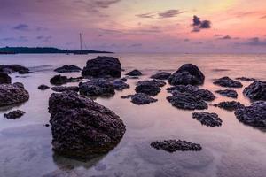 vista do mar com pedra ao nascer do sol.