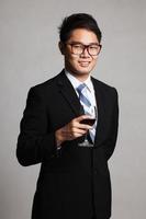 empresário asiático com copo de vinho tinto foto