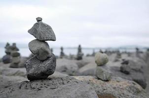 equilíbrio - pedras empilhadas na costa de reykjavik, islândia foto