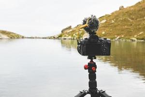 tripé com câmera configurada para filmar o lapso de tempo do lago ao ar livre foto