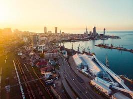 batumi, geórgia, 2021 - transporte em vista ferroviária batumi com panorama portuário e passeio marítimo com pôr do sol sobre horizonte e arranha-céus foto