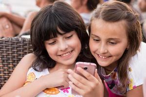 duas garotas com smartphone sorrindo