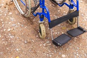 cadeira de rodas vazia em pé na estrada à espera de serviços ao paciente. cadeira de rodas para pessoas com deficiência estacionada ao ar livre. acessível para pessoa com deficiência. conceito médico de cuidados de saúde. foto