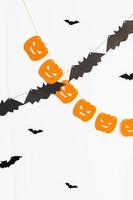 conceito de gostosuras ou travessuras. composição de férias com abóboras de decorações de guirlanda de halloween e morcegos isolados no fundo branco. preparação para festa de halloween. outono outono feliz dia das bruxas foto