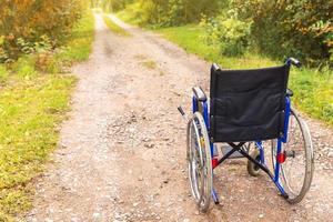 cadeira de rodas vazia em pé na estrada à espera de serviços ao paciente. cadeira de rodas para pessoas com deficiência estacionada ao ar livre. acessível para pessoa com deficiência. conceito médico de cuidados de saúde. foto