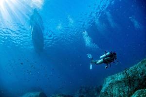 mergulhador debaixo d'água voltando ao barco de mergulho no azul foto