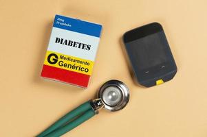 caixa de remédio falso com o nome da doença diabetes e um glicosímetro. foto