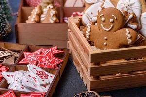 brinquedos de madeira da árvore de natal nas cores brancas e vermelhas, pão de gengibre e fatias secas de limão e toranja foto