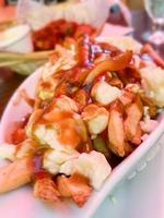 delicioso poutine com molho em um restaurante foto