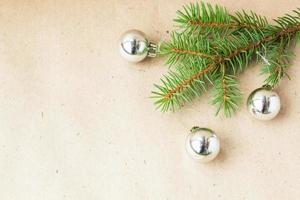 galhos de árvore do abeto decorados com bolas de natal prateadas como borda em um quadro de fundo de férias rústicas com espaço de cópia foto