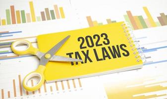 Texto das leis fiscais de 2023 no bloco de notas amarelo e fundo do gráfico foto