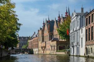 vista do canal para antigas casas de mercadores de tijolos em bruges, bélgica. antiga vista da cidade da europa medieval. foto