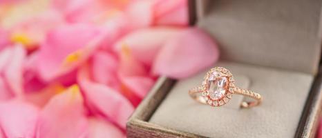 anel de diamante de casamento elegante na caixa de joias em fundo de pétala de rosa rosa linda close-up foto