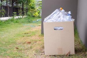 garrafas de plástico na caixa de lixo reciclada marrom foto