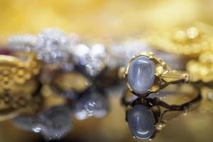 anéis de safira azul de joias de ouro vintage com reflexo no fundo preto foto