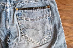 bolso traseiro de jeans azul no fundo de madeira foto