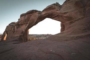 arco quebrado ao pôr do sol no parque nacional de arcos, perto de moab, utah foto
