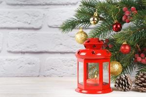 árvore de natal e lanterna decorativa com uma vela. foto