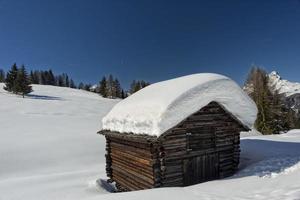 uma cabana de madeira no fundo da neve do inverno foto