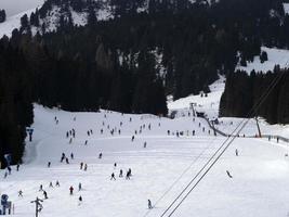 muitos esquiadores esquiando nas montanhas de neve do vale das dolomitas gardena foto