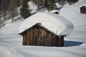 uma cabana de madeira no fundo da neve do inverno foto