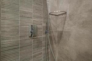 toalete e detalhe de uma cabine de chuveiro de canto com acessório de chuveiro de montagem na parede foto
