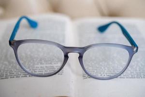 óculos de leitura azul claro isolados em um livro foto