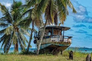 barco abandonado na praia de coco da polinésia foto