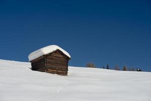 uma cabana de madeira no fundo da neve do inverno foto