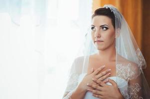 noiva linda se preparando no vestido de casamento branco com penteado