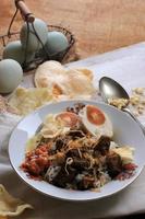 rawon, prato de sopa de carne preta de carne indonésia. cor preta feita de noz keluak como tempero principal foto
