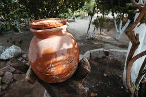 jarro de água de barro. jarro de barro feito à mão isolado. jarro tradicional. pote de cerâmica antigo foto