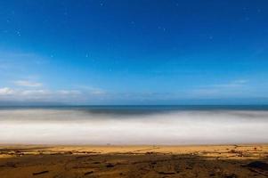 visão noturna do mar com céu estrelado foto