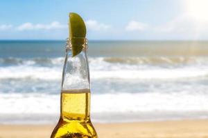 cerveja com fundo de copyspace de limão e praia foto