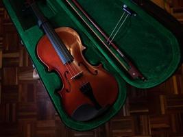 violino de madeira vermelho na caixa foto