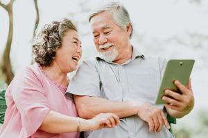 feliz casal sênior usando tablet foto