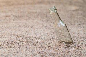 garrafa de vidro vazia na praia foto