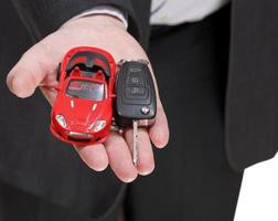 carro vermelho e chave na mão do vendedor foto