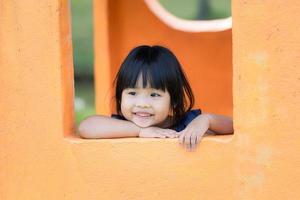 jovem menina asiática na janela gosta de parque infantil